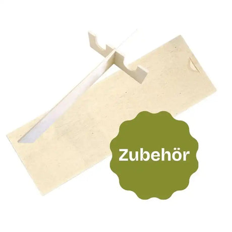 Ein hell gefärbter Holz- oder Kartonständer, der dazu gedacht ist, einen Gegenstand aufrecht zu halten, mit einem grünen, wellenförmigen Etikett, das „Zubehör“ (Accessoire) angibt.