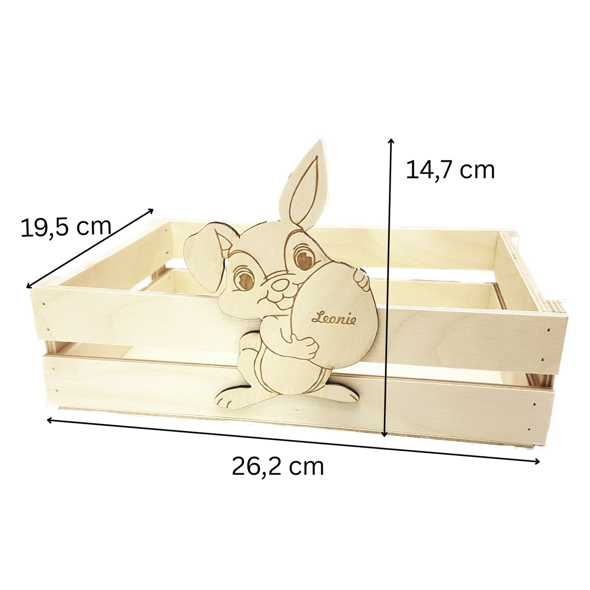 Eine hellfarbene Holzkiste mit einer geschnitzten Hasenfigur, die ein Ei hält, und dem Namen »Leonie« darauf graviert.