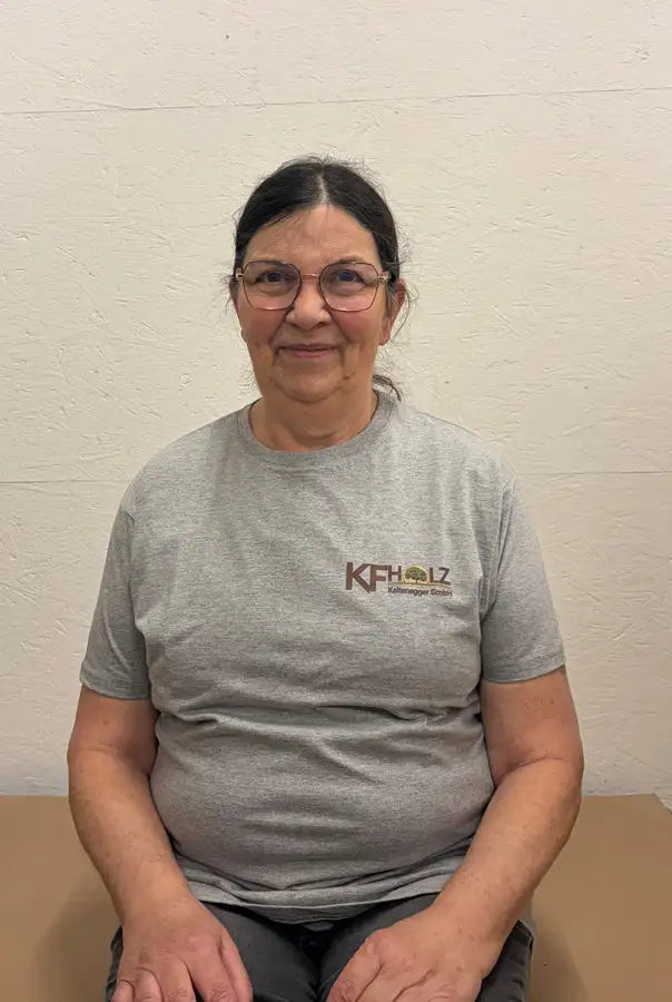 Graues kurzärmeliges T-Shirt mit einem braun-grünen Logo auf der Brust