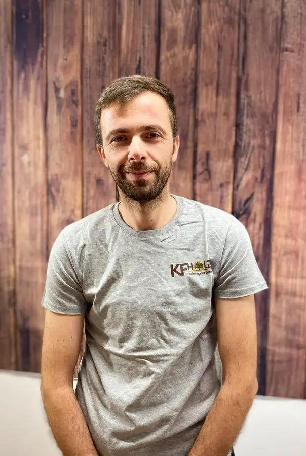 Graues kurzärmeliges T-Shirt mit einem braunen „kfh“-Logo auf der Brust.