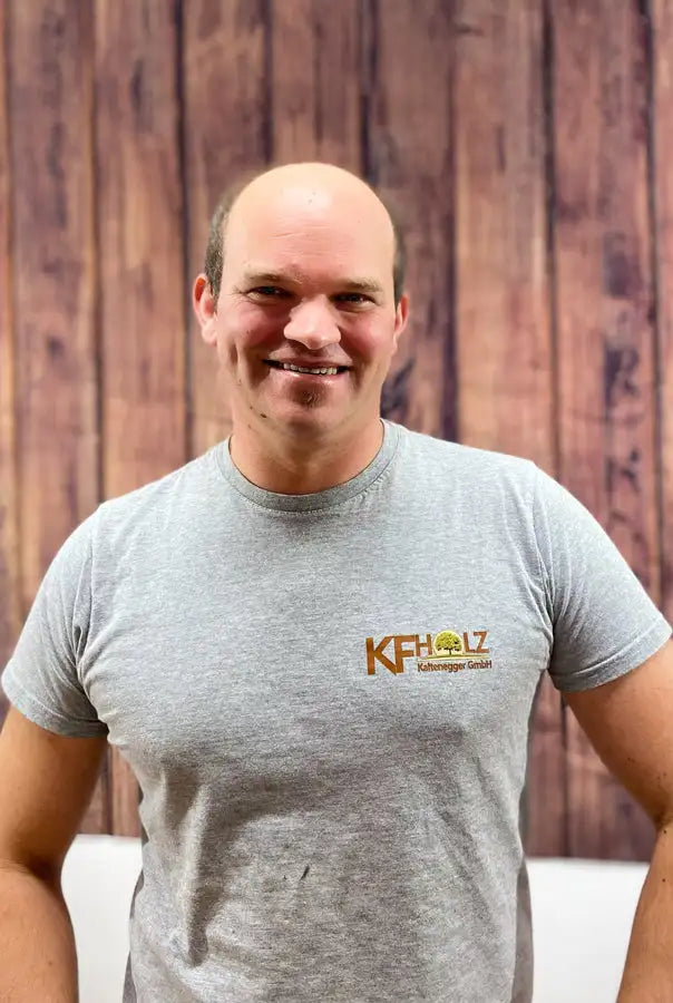 Graues kurzärmeliges T-Shirt mit einem goldfarbenen Logo auf der Brust