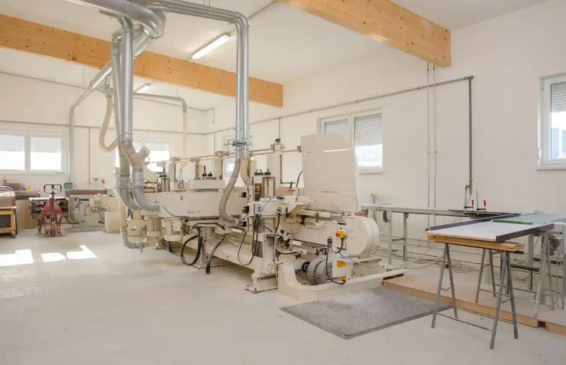Eine industrielle Holzbearbeitungsmaschine mit Staubabsaugsystem.