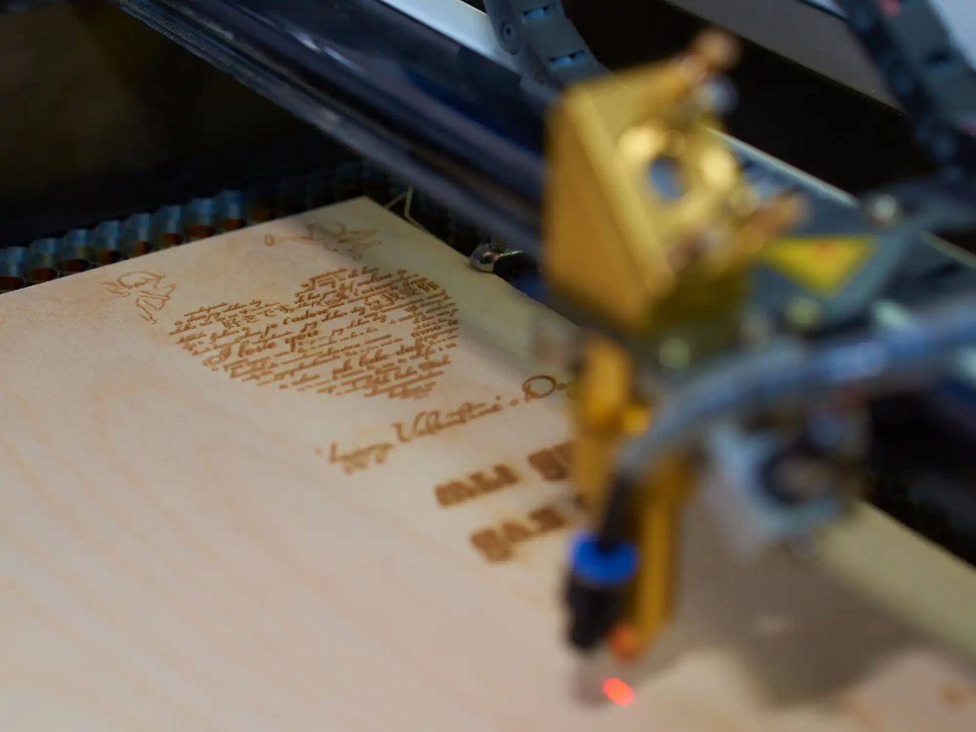 Ein Lasergravurgerät, das eine Holzoberfläche ätzt.