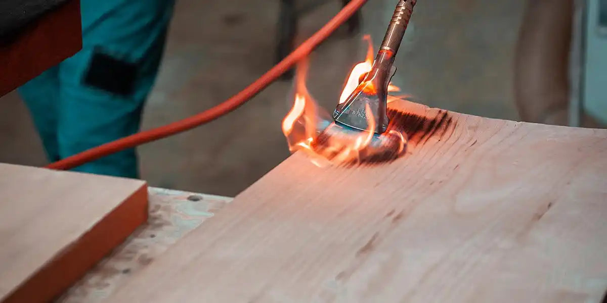 Eine Propanlampe, die Holz verbrennt, um einen verkohlten Effekt zu erzeugen.