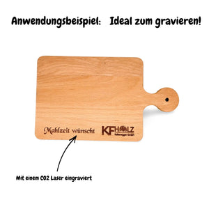 Holzschneidebrett mit Griff, graviertem Text ’Mahlzeit wünscht’ und Logo ’koholz’, helle braune Holzmaserungstextur.