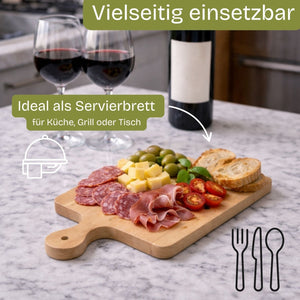 Hellfarbenes Holzschnittbrett mit Griff, auf dem eine Auswahl an gepökeltem Fleisch, Käsewürfeln, Oliven und in Scheiben geschnittenen Tomaten arrangiert ist.