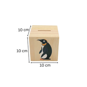Würfelspardose aus Holz mit einer Pinguin-Illustration.